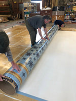 Load image into Gallery viewer, Carefully rolling up Humphries Floorcloth #2.