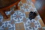 Load image into Gallery viewer, In-Situ image of this floocloth based on a Christopher Dresser pattern with Greek Key and Fleur de lis elements. Scale provided by Tanuki. Photo by Sally Painter.