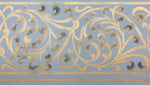 Load image into Gallery viewer, A close up of the scrolling floorcloth border in gold with blue highlights.