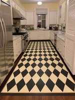 Load image into Gallery viewer, In-situ image of this 5'3" x 15' 9" harlequin patterned floorcloth in a soft yellow-white and charcoal colorway.