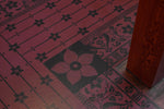 Load image into Gallery viewer, Image of an inside corner of this floorcloth, shaped to fit around a stairway.