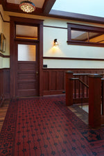 Load image into Gallery viewer, In-situ image of this floorcloth based on a pattern from Christopher Dresser's "Studies in Design" c. 1875.  This floorcloth was shaped to fit around a stairwell. Photo by Sally Painter.