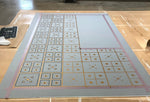 Load image into Gallery viewer, Image of this floorcloth in production in the middle of the second of three stencil passes.