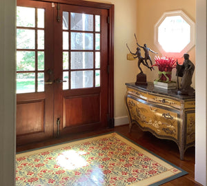 An in-situ photo of this floorcloth with a floral motif with a lattice of roses.