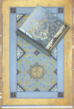 Load image into Gallery viewer, This image shows this floorcloth, based on a Christopher Dresser pattern, with it&#39;s palette inspiration, a piece of wallpaper, c. 1880, lying on top.
