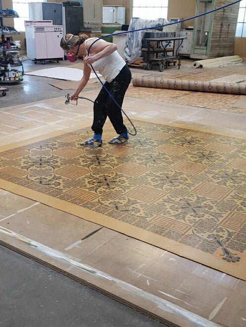 A production image of polyurethane being applied to Greek Key Floorcloth #4.