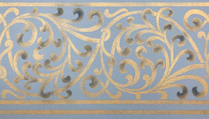 A close up of the scrolling floorcloth border in gold with blue highlights.