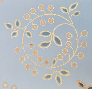 A close up of one of the circular leaf and berry motifs that adorn the center of this floorcloth.