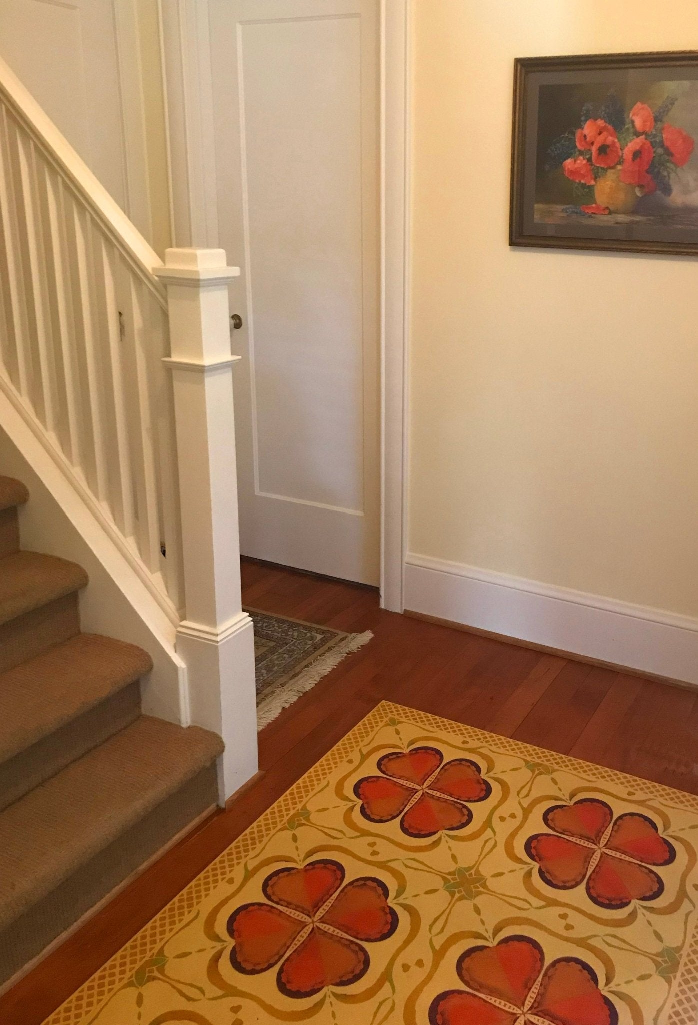 An in-situ image of Honeymoon Floorcloth #1.  The palette was inspired by the Poppy painting on the wall along with other artwork in this hallway.