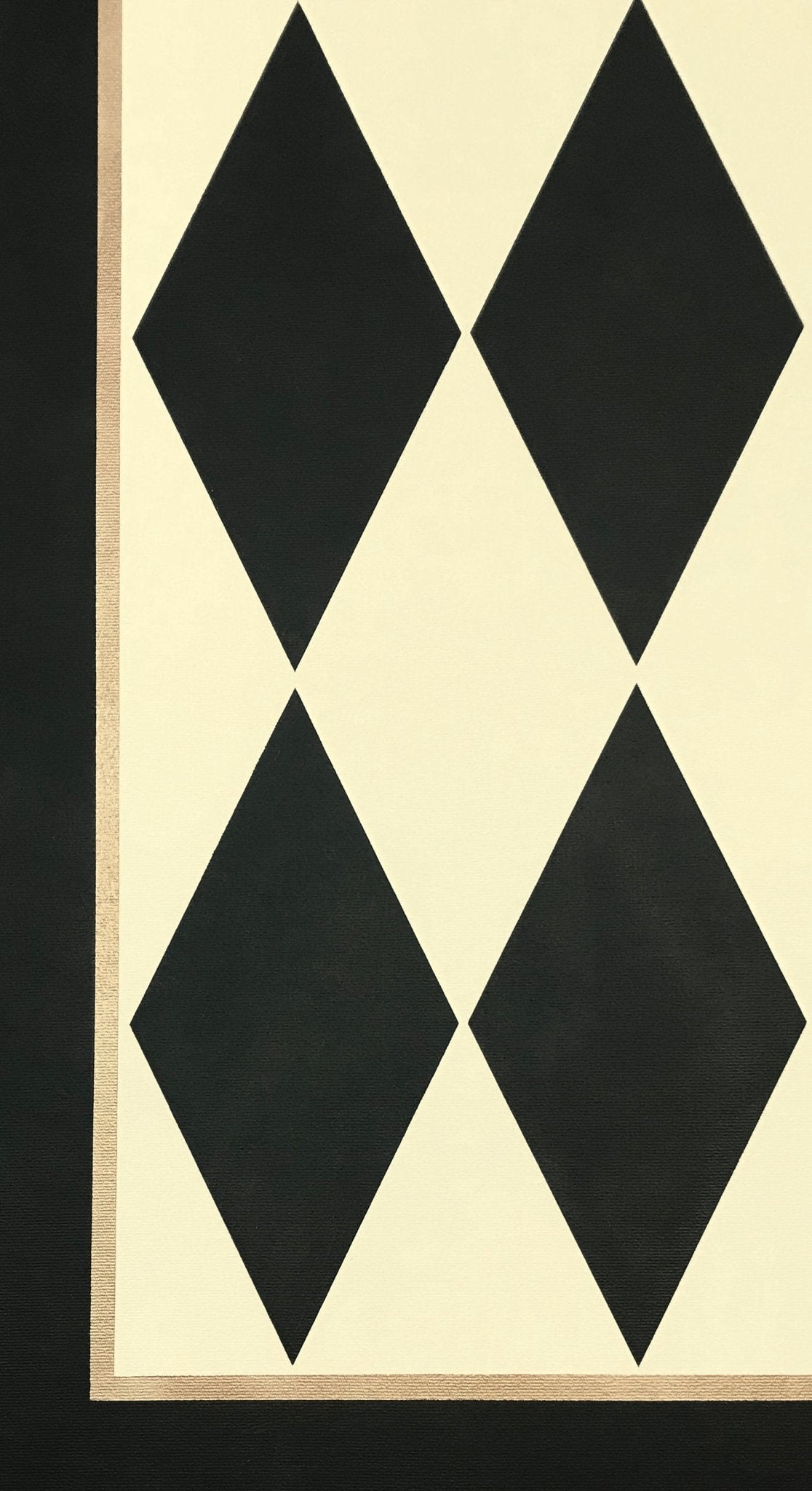A close up image of this harlequin patterned floorcloth in a soft yellow-white and charcoal colorway.