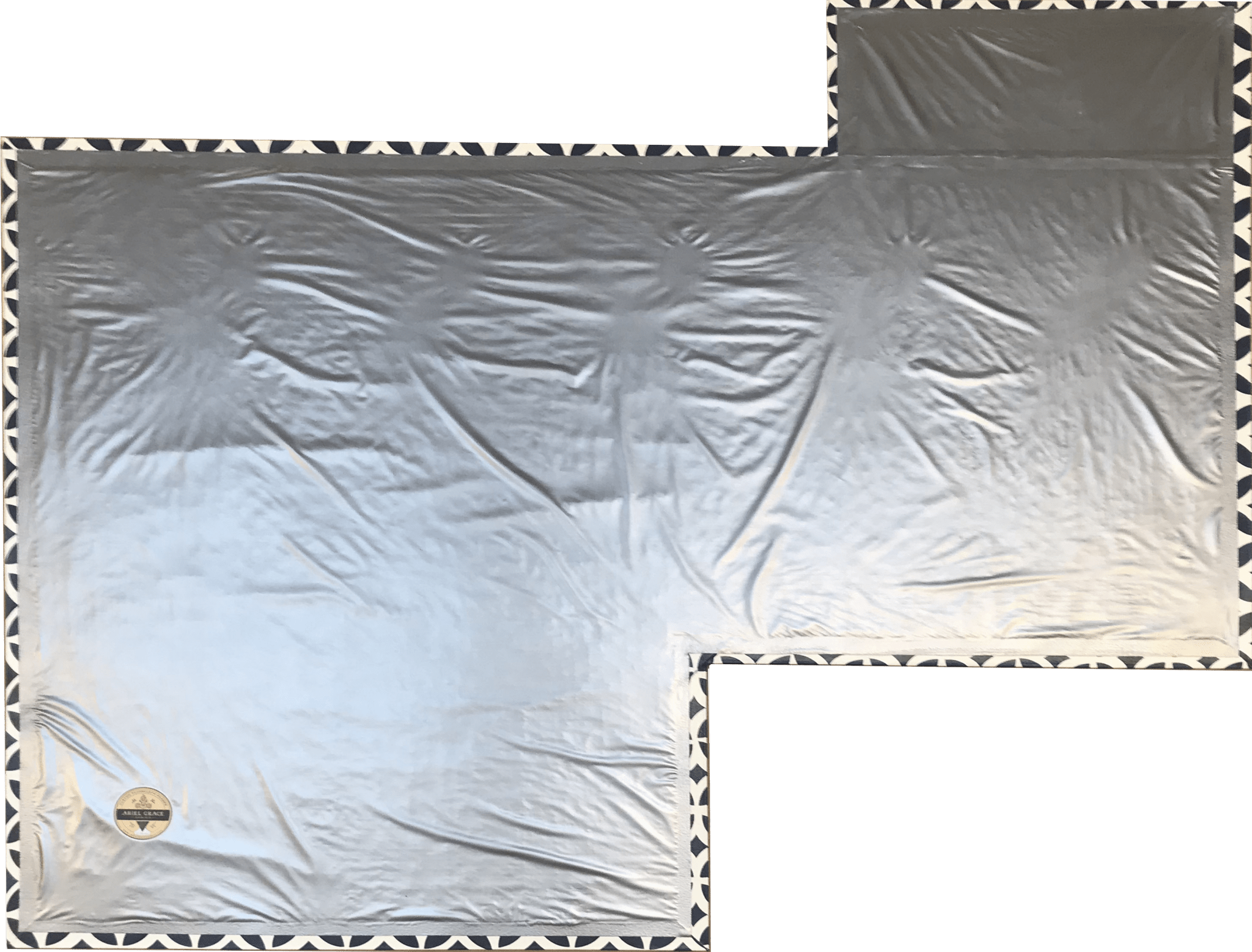 The backside of this floorcloth with has a two inch adhered hem. A layer of carpet padding has been adhered to the cove created by the hem, and waterproof fabric has been adhered to the hem.