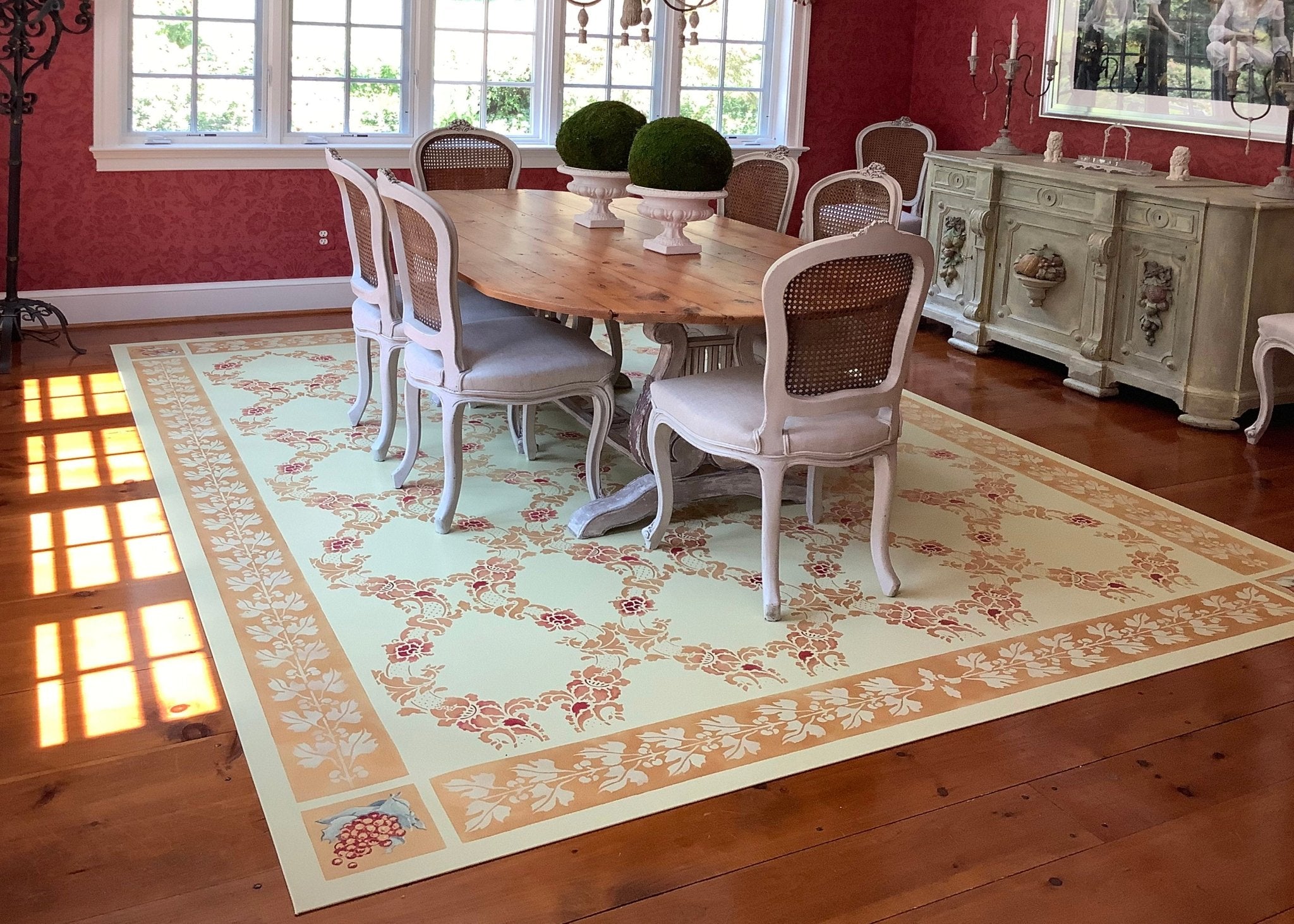 In-situ image of this custom floorcloth with the buffet that was the inspiration for its hand-painted corner motifs.