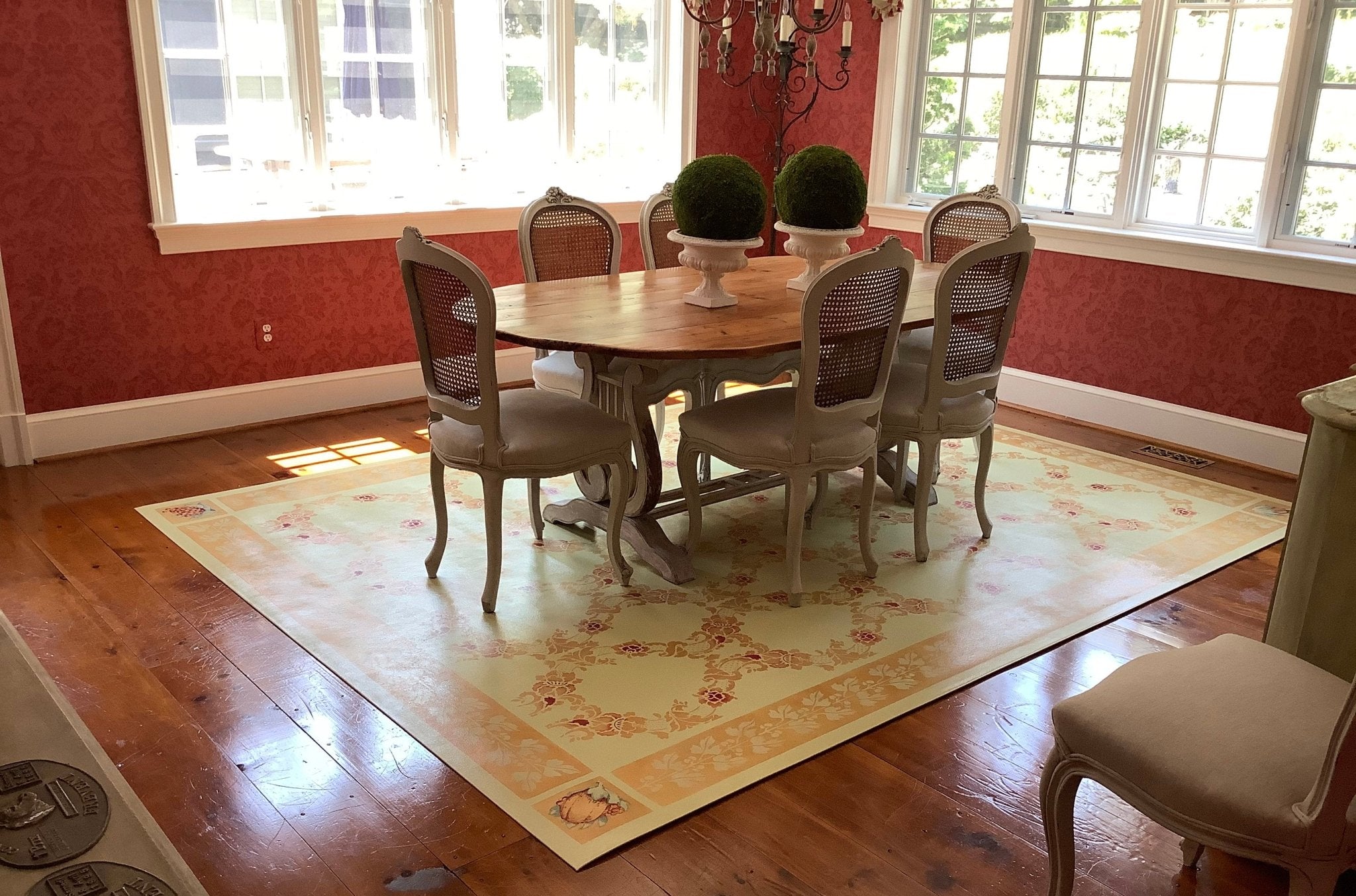 In-situ image of this custom floorcloth with a trellis-like center and border vines.