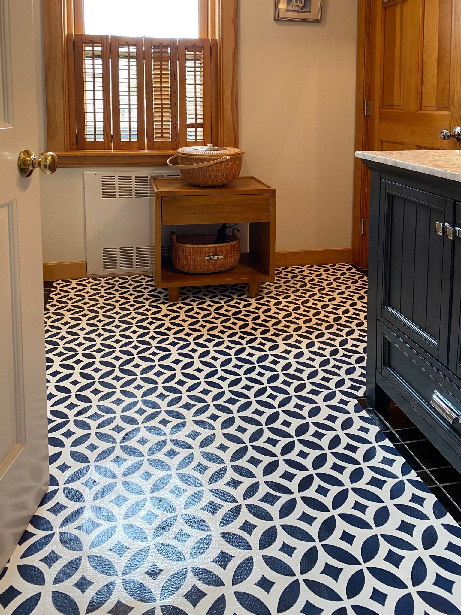 Shaped floorcloth with interlocking circle pattern installed in bathroom.